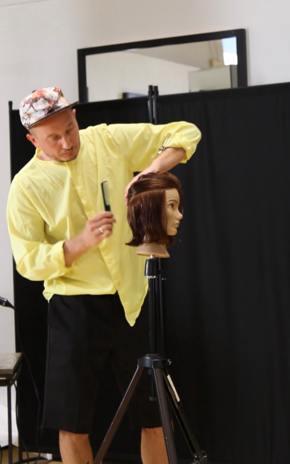 Andrii Gerashchenko demonstrating haircut form on a mannequin