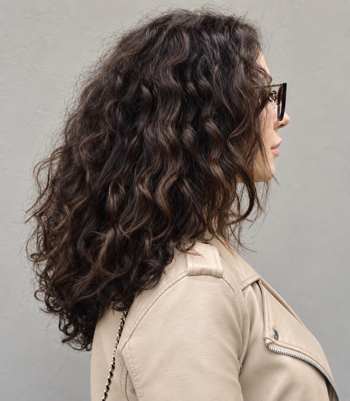 Long curly brunette haircut by Andrii Gerashchenko